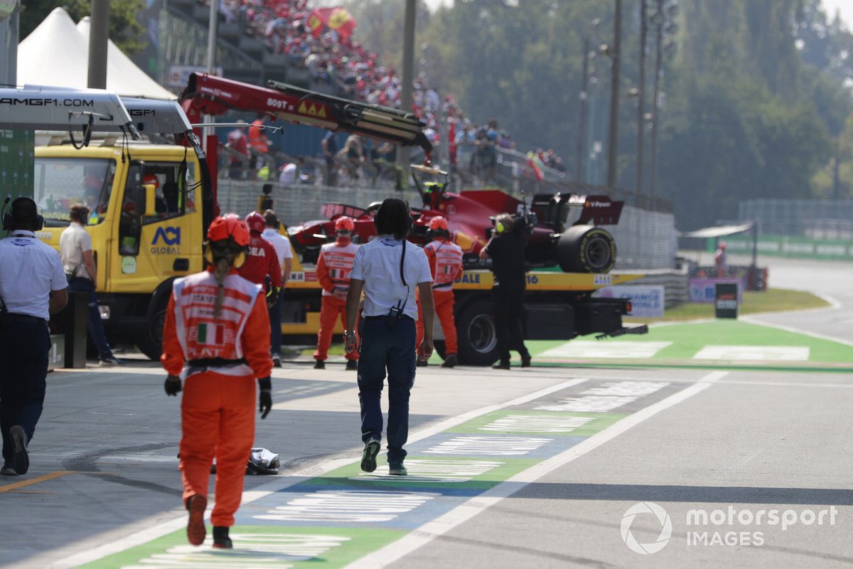 Los comisarios llevan el coche de Carlos Sainz Jr., Ferrari SF21, a los pits.