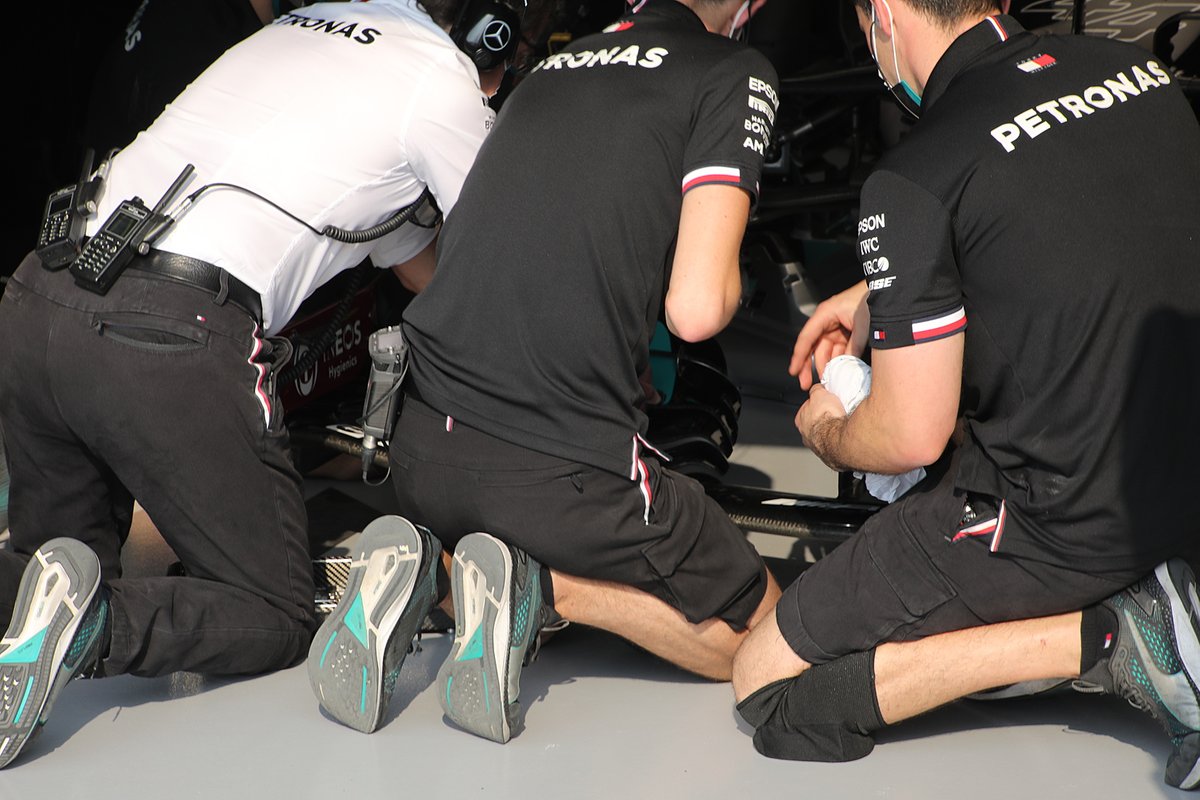 I meccanici della Mercedes W12 sistemano l'ala anteriore di Hamilton