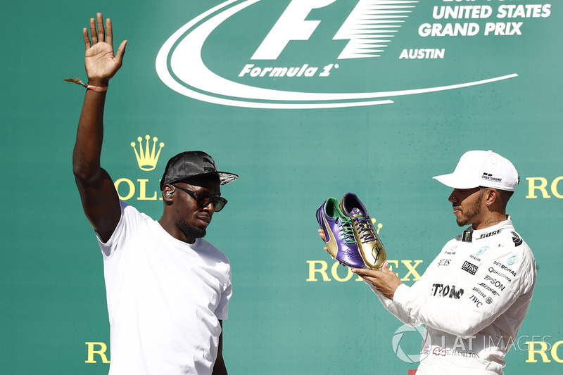 Usain Bolt le regala un par de zapatillas de atletismo al ganador de la carrera de Austin, Lewis Hamilton, Mercedes AMG F1, en el podio