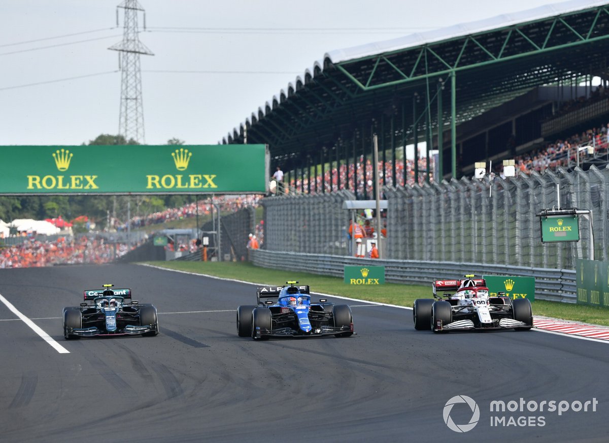 Esteban Ocon, Alpine A521, y Sebastian Vettel, Aston Martin AMR21, ponen una vuelta abajo a Antonio Giovinazzi, Alfa Romeo Racing C41.