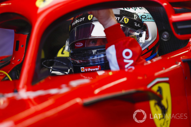 Kimi Raikkonen, Ferrari, in cockpit, reaches towards his halo