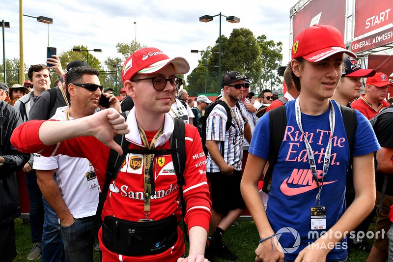 Spectators show their reaction to the news of the cancellation of the Grand Prix