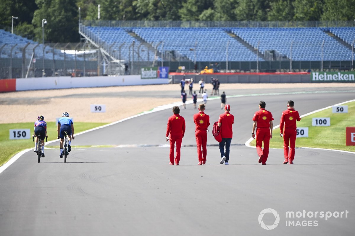 Valtteri Bottas, Mercedes-AMG Petronas F1 and Tiffany Cromwell cycle the track past Sebastian Vettel, Ferrari as he walks the track with his engineers