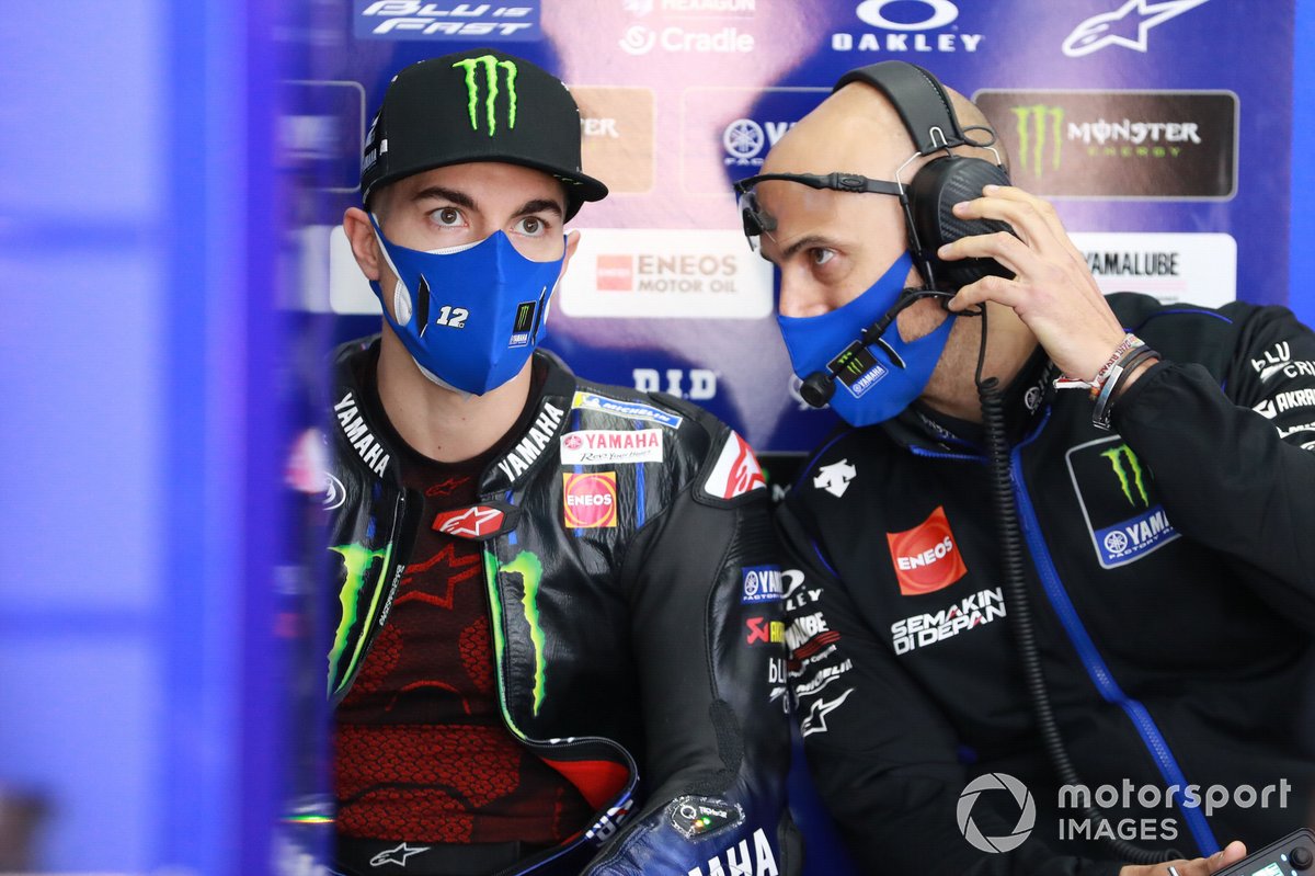 Pembalap Yamaha Factory Racing Maverick Vinales mendengarkan penjelasan dari salah satu krunya.