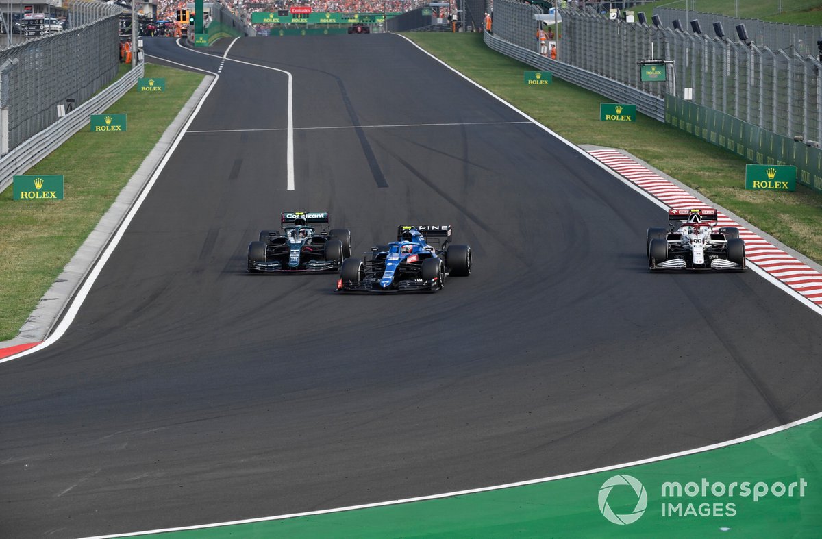 Esteban Ocon, Alpine A521, Sebastian Vettel, Aston Martin AMR21, as they lap Antonio Giovinazzi, Alfa Romeo Racing C41