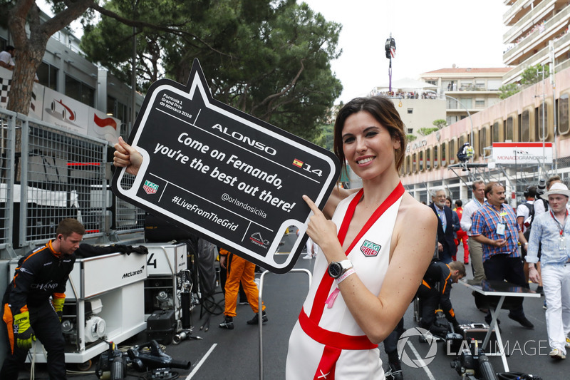 A grid girl holds a promotional board for Fernando Alonso, McLaren