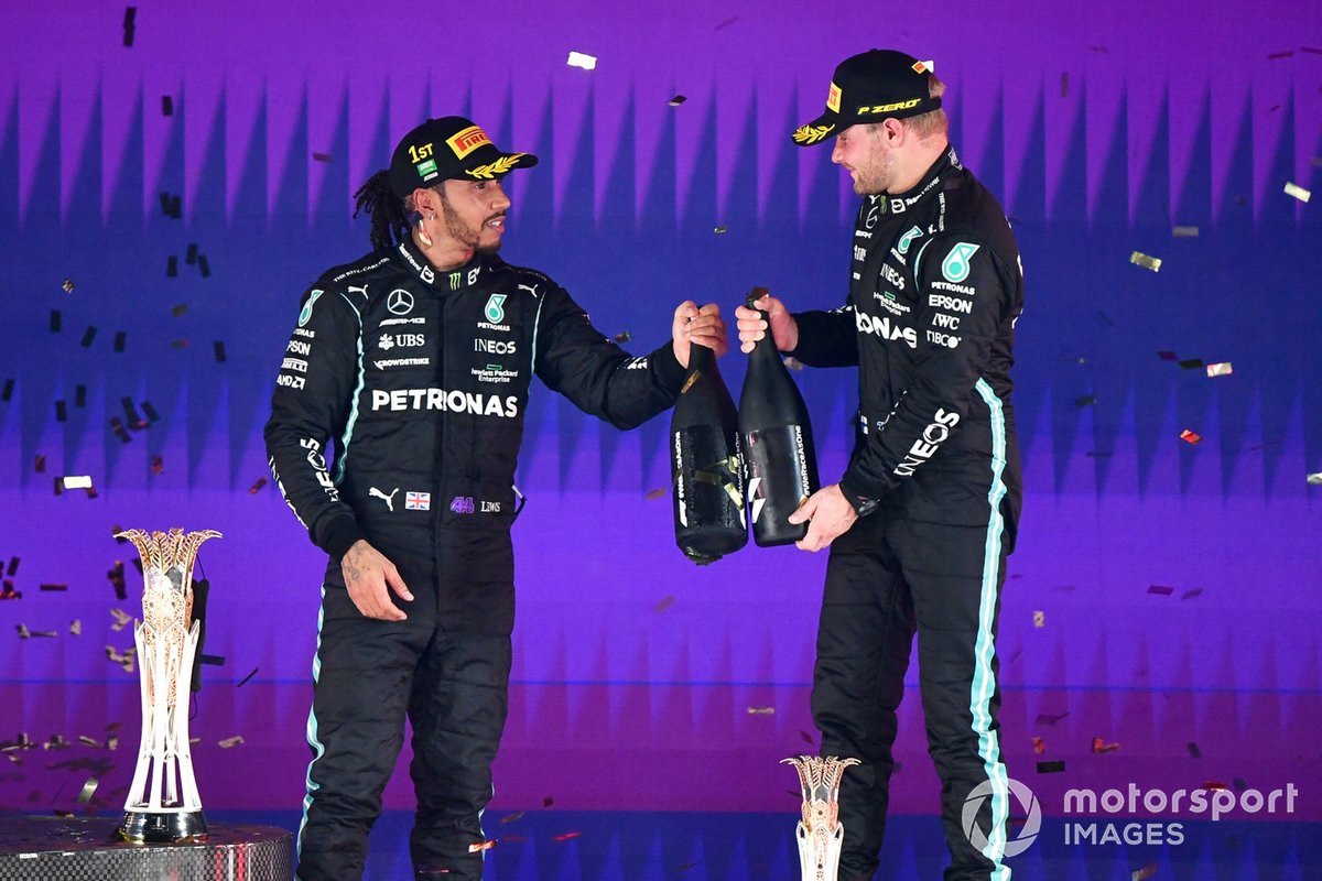Lewis Hamilton, Mercedes, pemenang, dan Valtteri Bottas, Mercedes, peringkat ketiga, merayakan sukses di podium F1 GP Arab Saudi 2021.