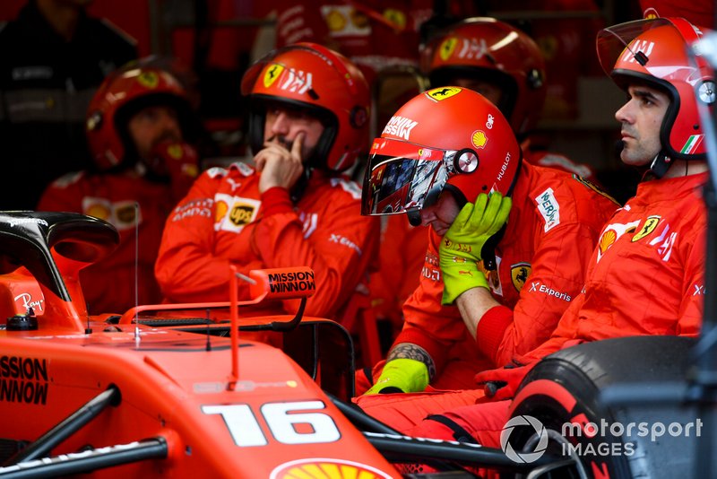 Mechanic sat in the garage next to the retired car of Charles Leclerc, Ferrari SF90