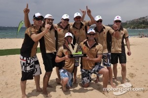 The team of New Zealand V8 Supercar drivers and celebrities pose with the trophy after they beat a team of their Australian counterparts in a beach cricket match