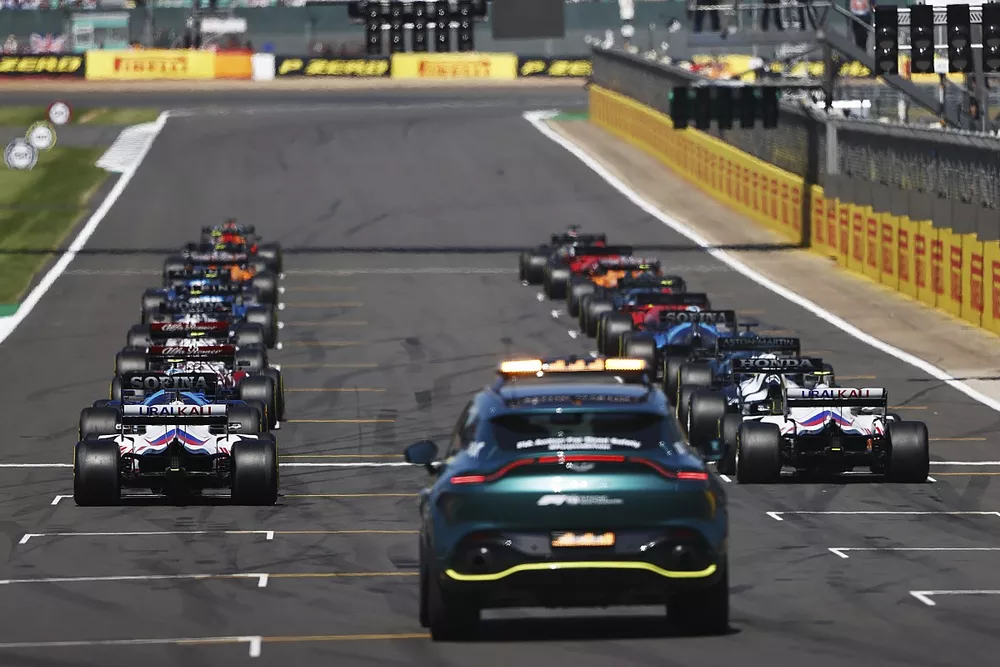 Max Verstappen, Red Bull Racing RB16B, and Lewis Hamilton, Mercedes W12, prepare to lead the drivers away at the start