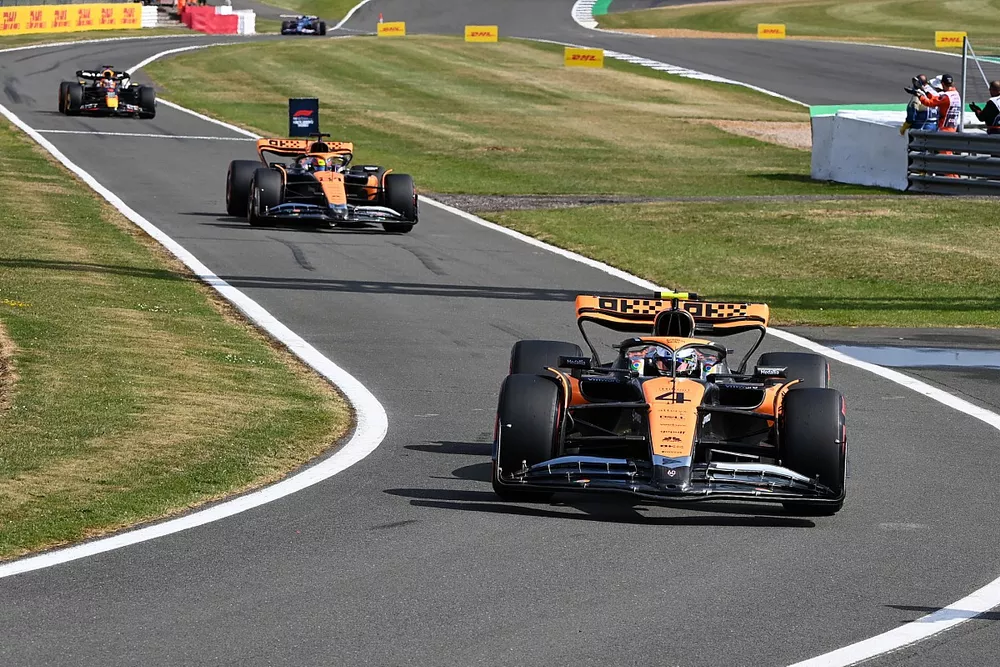 Lando Norris, McLaren MCL60, Oscar Piastri, McLaren MCL60, en el pit lane