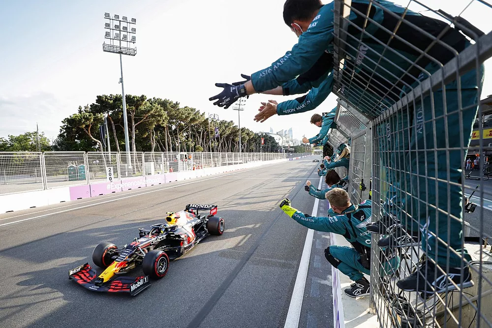 Sergio Perez, Red Bull Racing RB16B, 1st position, is cheered over the line by members of the Aston Martin team