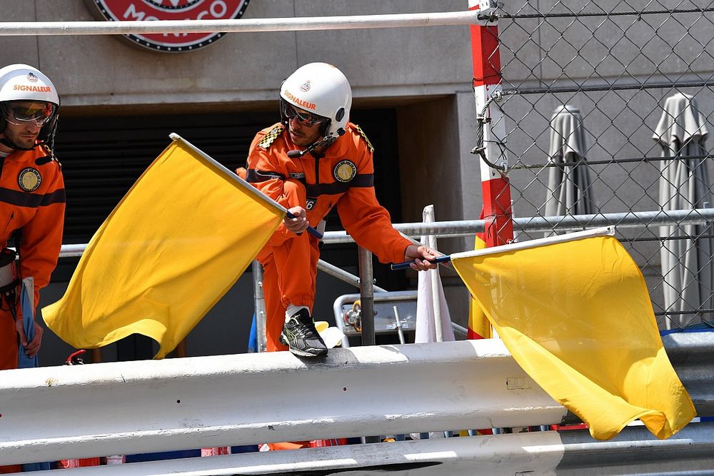 Marshals wave the yellow flags after the crash of Max Verstappen, Red Bull Racing RB14