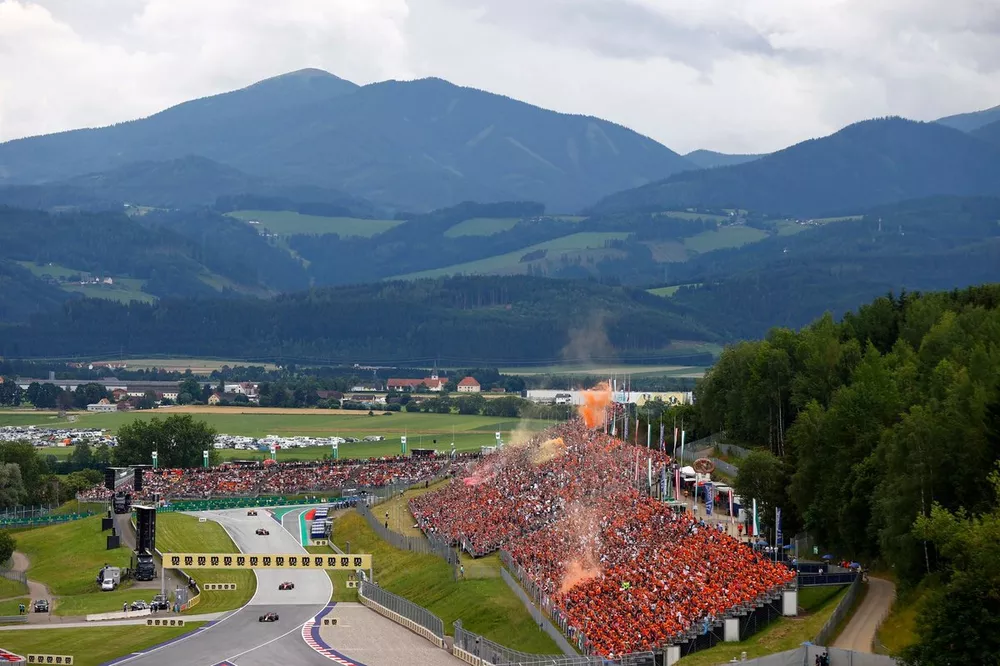 Max Verstappen, Red Bull Racing RB19, Charles Leclerc, Ferrari SF-23, Carlos Sainz, Ferrari SF-23, in de formatieronde terwijl oranje rook uit de tribune komt