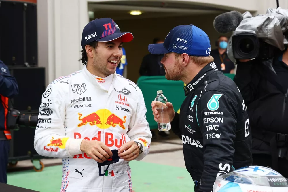 Sergio Perez, Red Bull Racing, 3rd position, and Valtteri Bottas, Mercedes, 1st position, talk in Parc Ferme