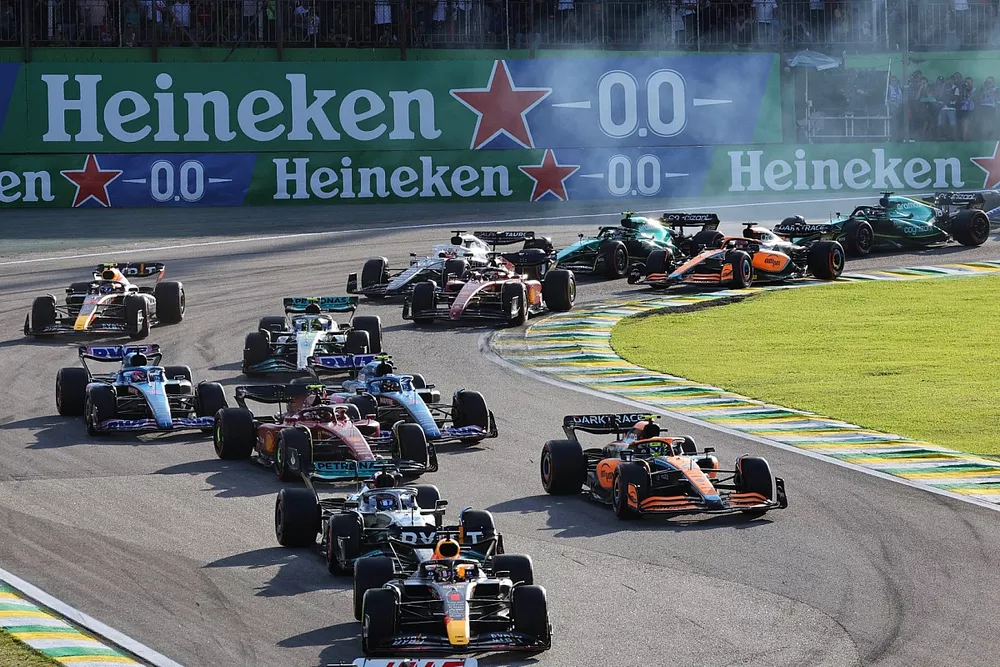 Kevin Magnussen, Haas VF-22, Max Verstappen, Red Bull Racing RB18, seguido de George Russell, Mercedes W13, Lando Norris, McLaren MCL36, el resto del pelot&oacute;n al inicio de la carrera
