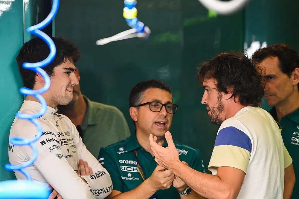 Lance Stroll, Aston Martin, talks to new team-mate Fernando Alonso, Aston Martin, as Pedro de la Rosa looks on