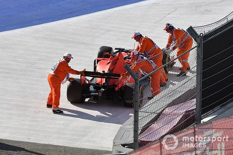 Los oficiales mueven el coche de Sebastian Vettel, Ferrari SF90