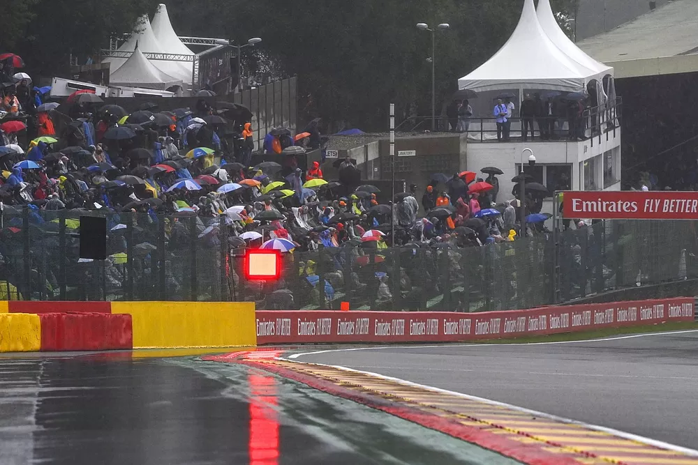 Puddles forming on the circuit and fans under umbrellas