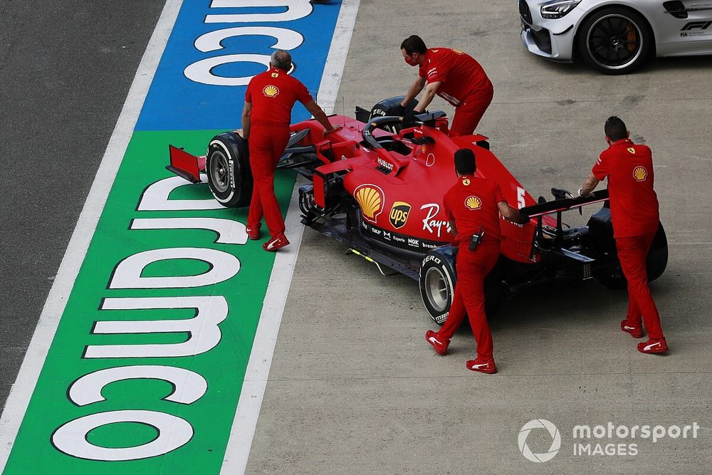 The Sebastian Vettel Ferrari SF1000 is pushed by mechanics in the pit lane