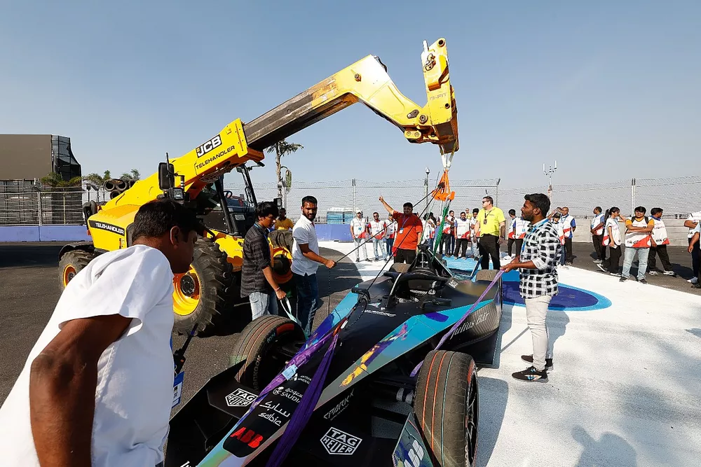 A car is lifted by a JCB
