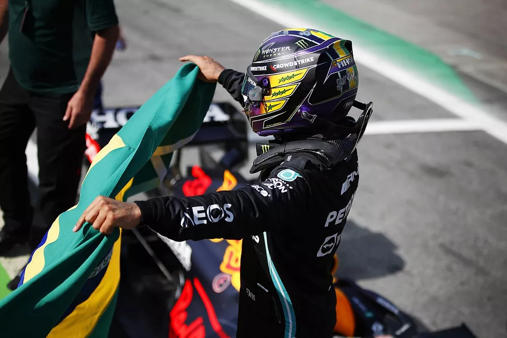Le vainqueur Lewis Hamilton, Mercedes, fête dans le parc fermé avec un drapeau Brésilien