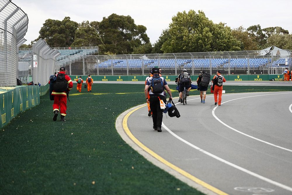 Los oficiales de pista dejan sus posiciones tras la noticia de que el evento es cancelado