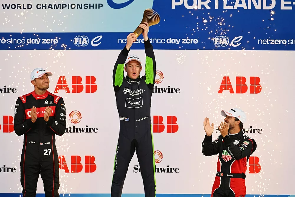 Jake Dennis, Andretti Autosport, 2nd position, Nick Cassidy, Envision Racing, 1st position, with his trophy, Antonio Felix da Costa, Porsche, 3rd position, on the podium