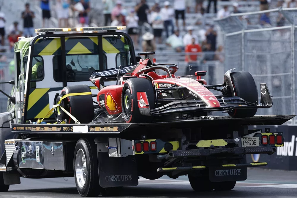 The crash damaged Charles Leclerc Ferrari SF-23 is returned to the pits on the back of a truck