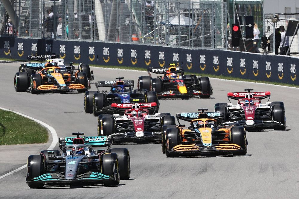 George Russell, Mercedes W13, Daniel Ricciardo, McLaren MCL36, Zhou Guanyu, Alfa Romeo C42, Valtteri Bottas, Alfa Romeo C42, Alex Albon, Williams FW44, the remainder of the field on the opening lap