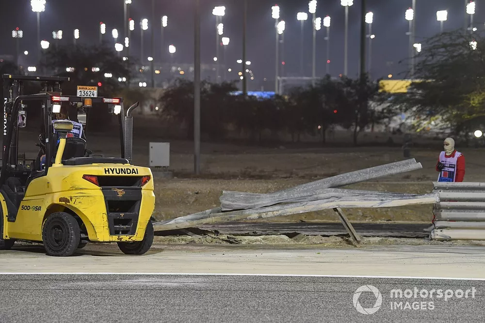 Los oficiales retiran los restos despu&eacute;s del choque de Romain Grosjean, Haas VF-20, en la primera vuelta