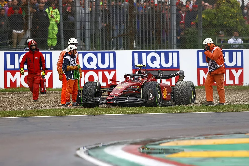 Los oficiales asisten a Carlos Sainz Jr., Ferrari F1-75, en la grava