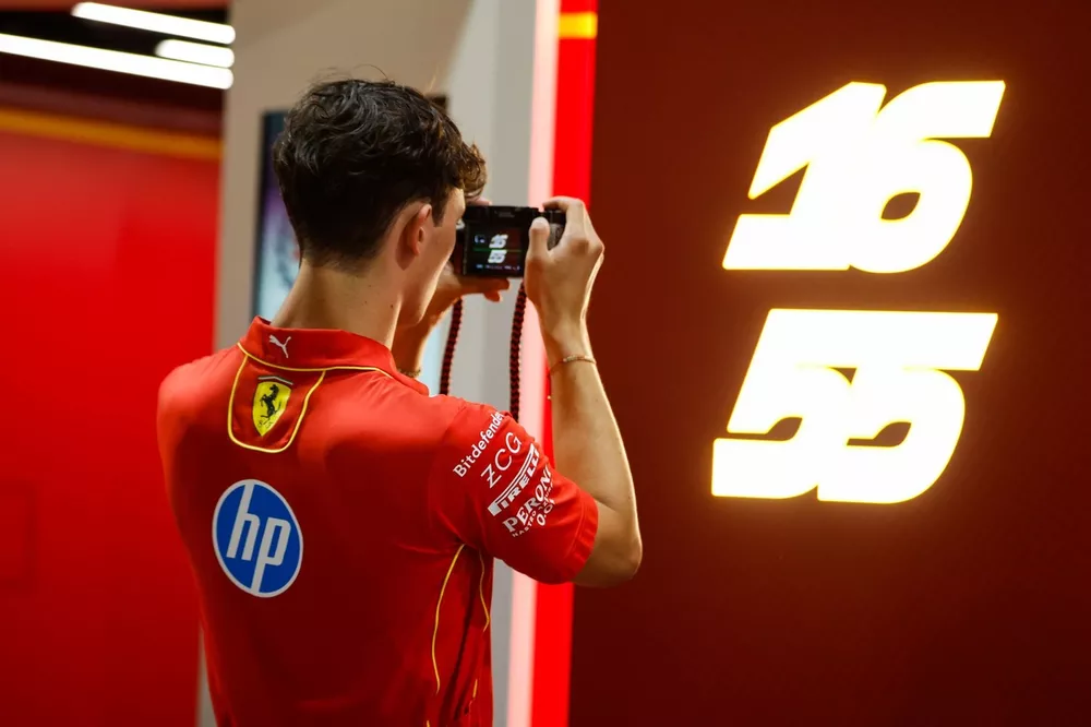 Oliver Bearman, Reserve Driver, Ferrari and Haas F1 Team, takes a picture of the driver numbers on the back of the Scuderia Ferrari garage