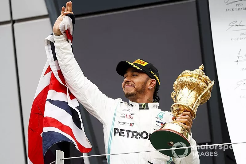 Race winner Lewis Hamilton, Mercedes AMG F1 on the podium with the trophy and a flag 