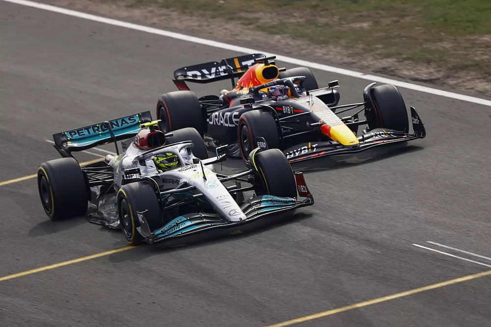 Lewis Hamilton, Mercedes W13, battles with Max Verstappen, Red Bull Racing RB18, for the lead after the restart
