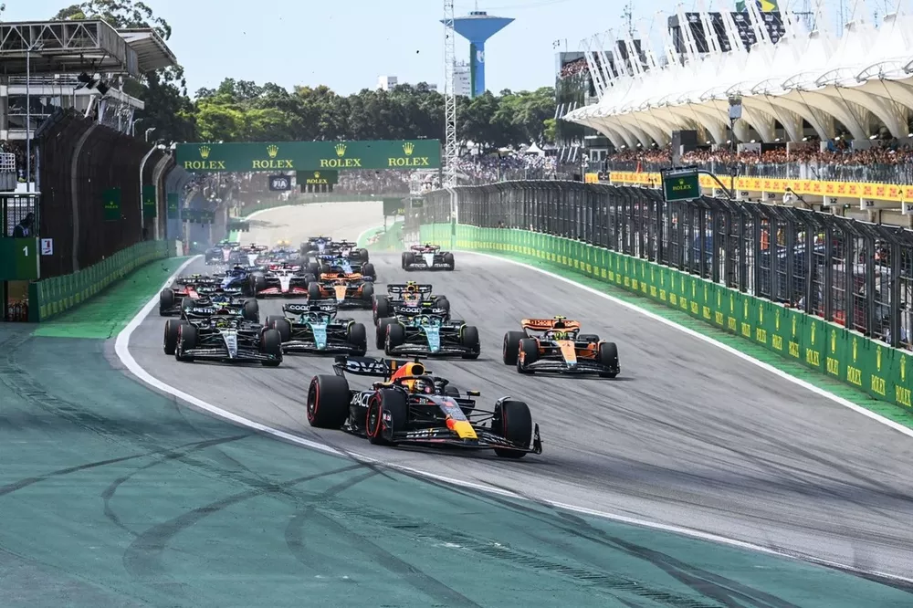 Max Verstappen, Red Bull Racing RB19, Lando Norris, McLaren MCL60, Lewis Hamilton, Mercedes F1 W14, Fernando Alonso, Aston Martin AMR23, Lance Stroll, Aston Martin AMR23, de rest van het veld terwijl Kevin Magnussen, Haas VF-23, Alex Albon, Williams FW45 crasht.