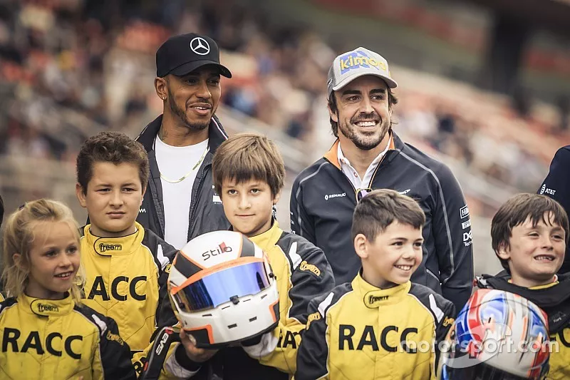 Lewis Hamilton, Mercedes-AMG F1 et Fernando Alonso, McLaren, avec des jeunes pilotes de karting