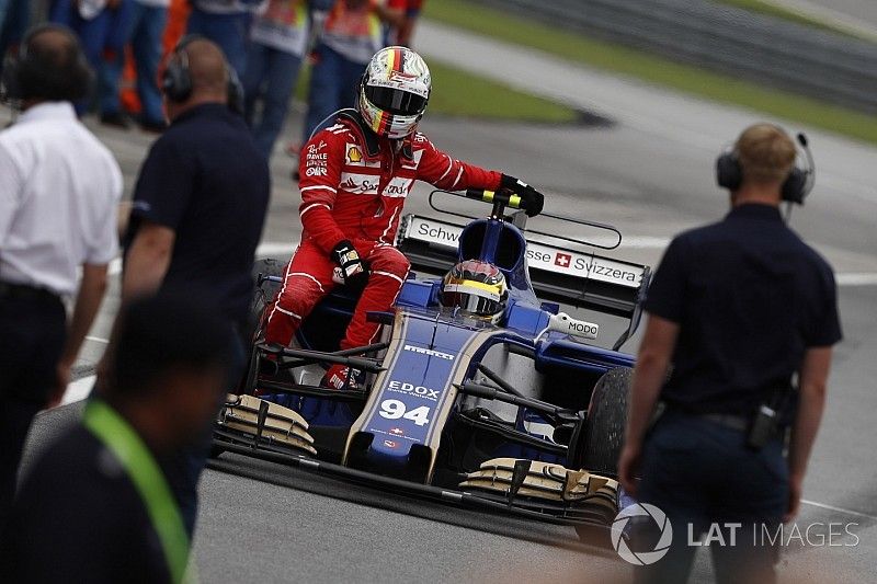 Sebastian Vettel, Ferrari, rides back to the pits on the sidepod of the Pascal Wehrlein Sauber C36