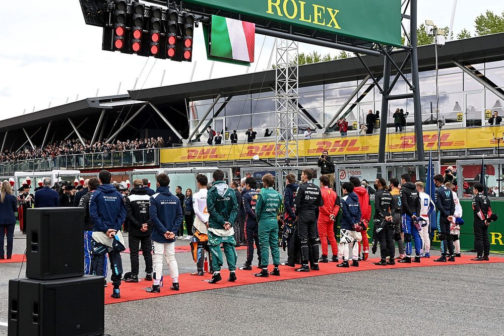 The drivers stand on the grid for the national anthem prior to the start