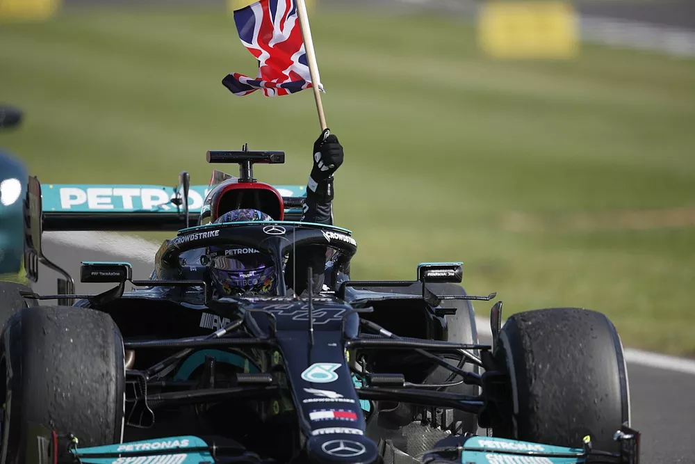 Lewis Hamilton, Mercedes W12, 1st position, flies a Union flag from his cockpit in celebration on his way to Parc Ferme