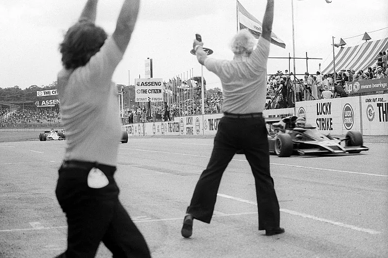 Colin Chapman, propietario del equipo Lotus, celebra mientras Ronnie Peterson, Lotus 78 cruza la l&iacute;nea de meta para ganar el GP 