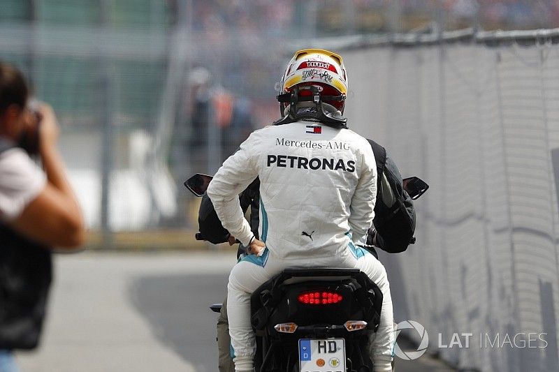 Lewis Hamilton, Mercedes AMG F1, rides back to the pits on the back of a motorcycle