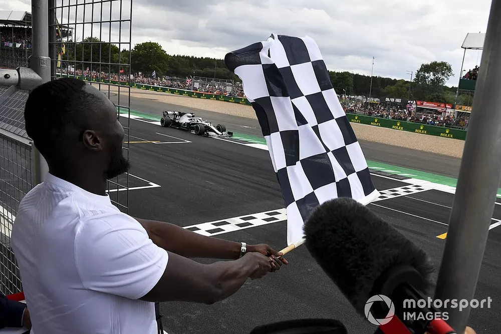 Stormzy, Rapper waves the finish flag while Lewis Hamilton, Mercedes AMG F1 W10 crosses the line
