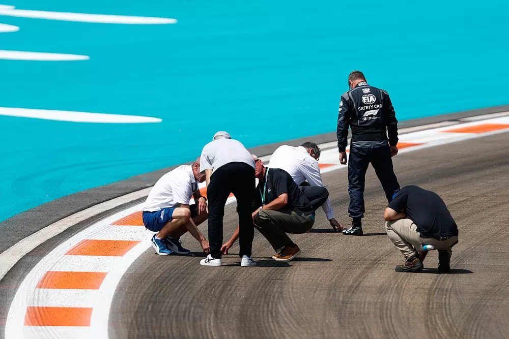 Oficiales, incluyendo a Niels Wittich, Director de Carrera, FIA, Bernd Maylander, conductor del coche de seguridad, inspeccionan la pista