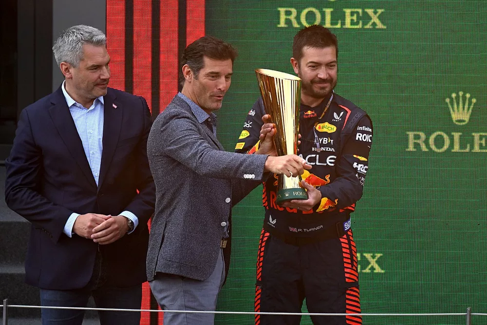 Miembro de Red Bull recoge el trofeo de Constructores de manos de Mark Webber
