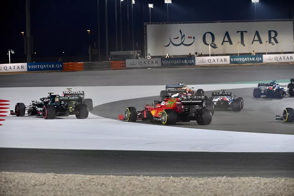 Sergio Perez, Red Bull Racing RB16B, and Sebastian Vettel, Aston Martin AMR21, run wide ahead of Charles Leclerc, Ferrari SF21, at the start