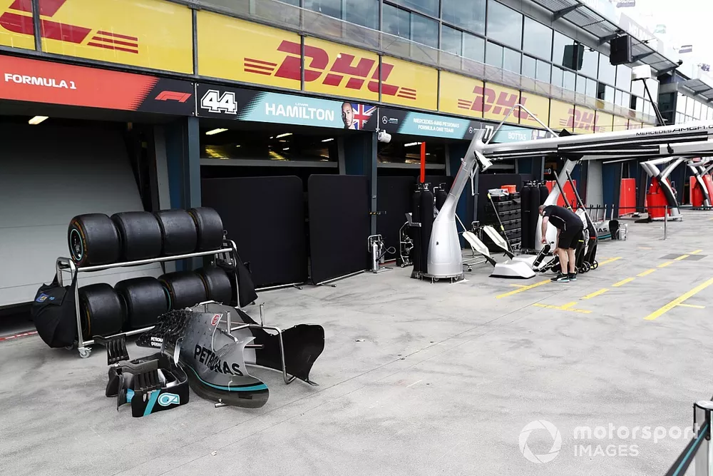 The Mercedes team start to pack up in the pit lane