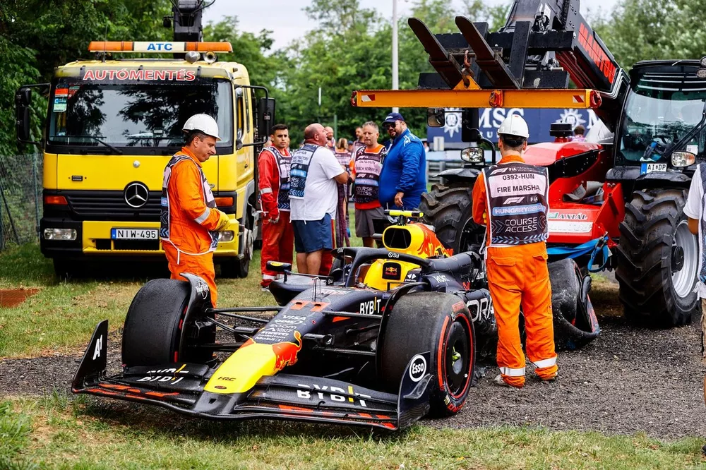 Marshals with the damaged car of Sergio Perez, Red Bull Racing RB20