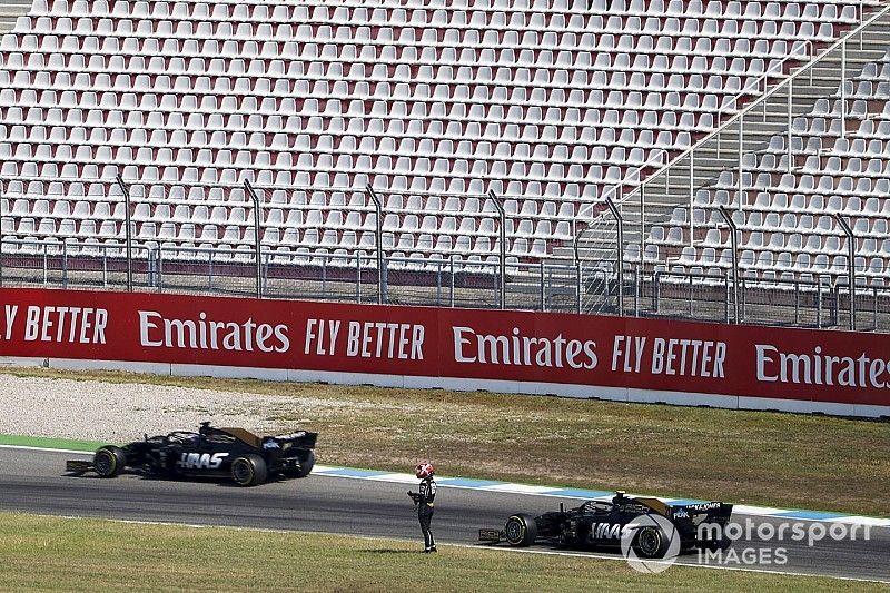 Romain Grosjean, Haas F1 Team VF-19, passes the stopped car of Kevin Magnussen, Haas F1 Team VF-19