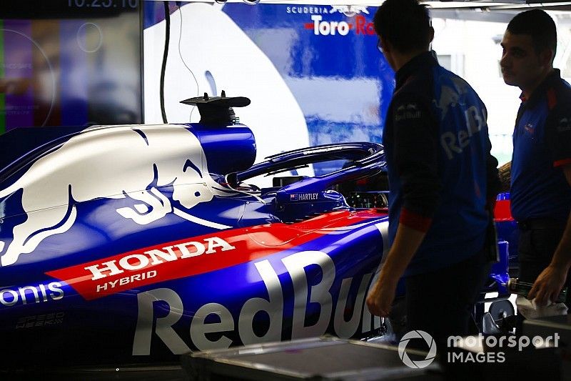 Los mecánicos de Toro Rosso Honda trabajan en el garaje junto al Brendon Hartley Toro Rosso STR13